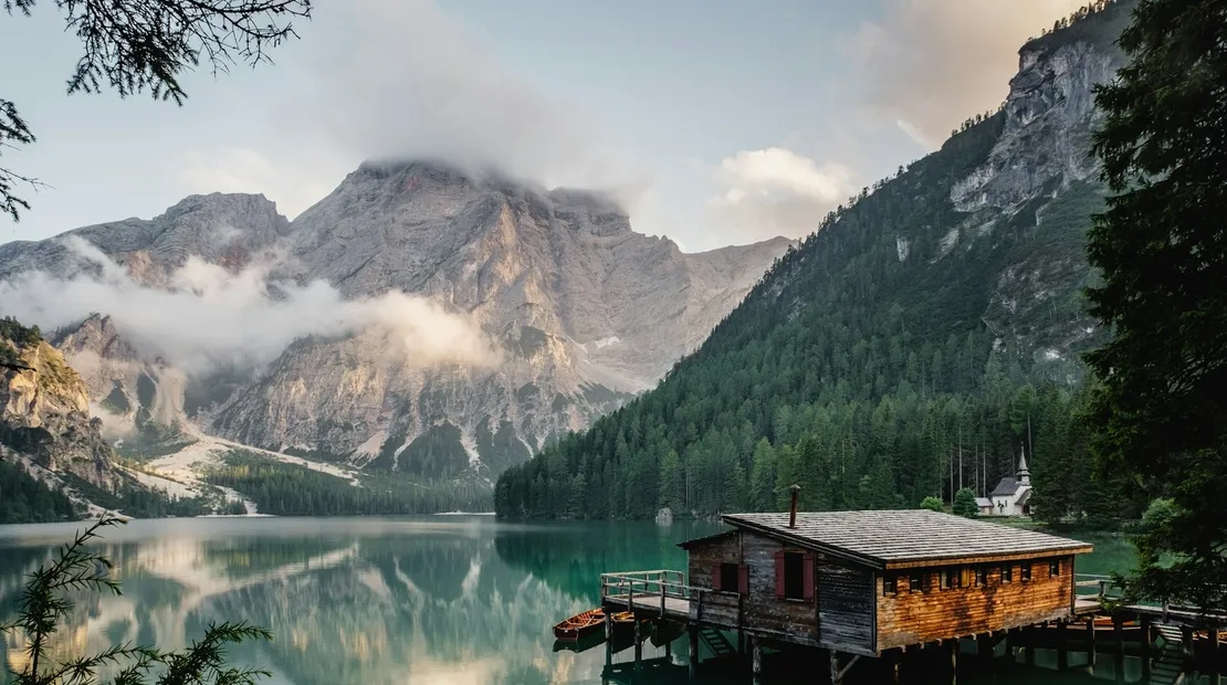 A still alpine lake reflecting mountains in warm light