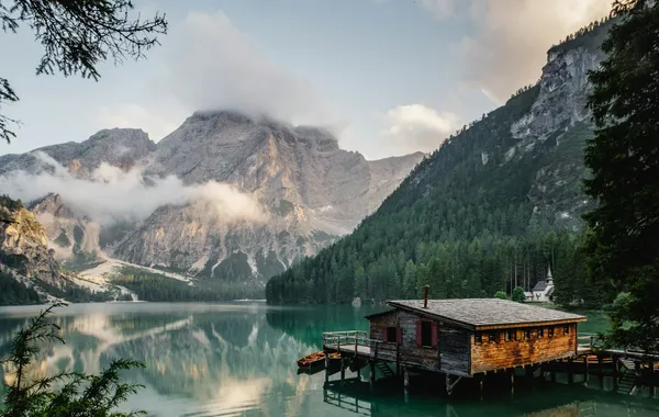A still alpine lake reflecting mountains in warm light